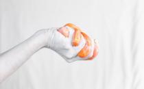 A white hand holding orange slime